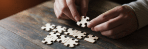 Hands assembling a unique wooden puzzle.