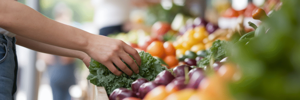 Hands choosing fresh vegetables at a market.