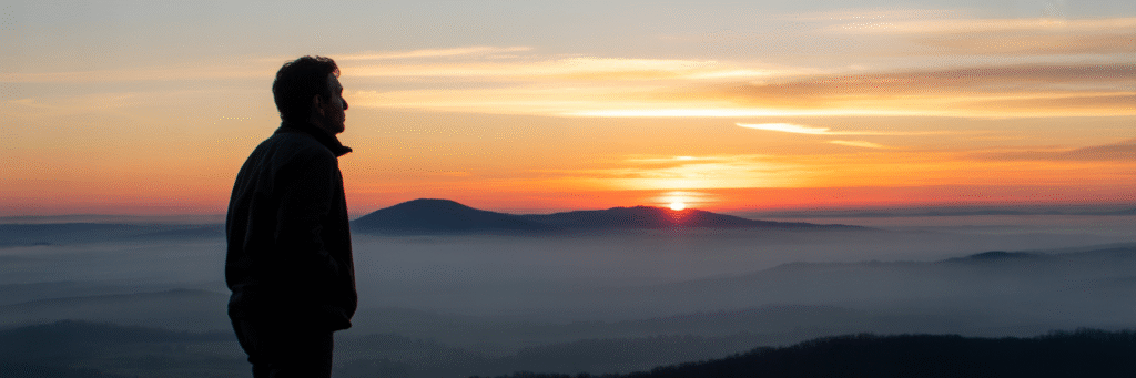 Person watching sunrise over Shenandoah Valley mountains.
